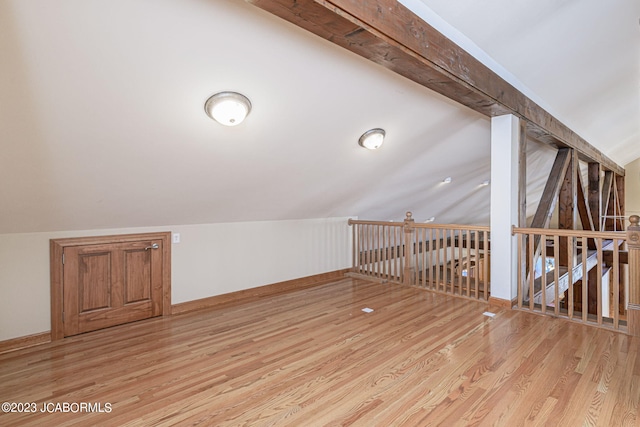 additional living space featuring light hardwood / wood-style floors and lofted ceiling