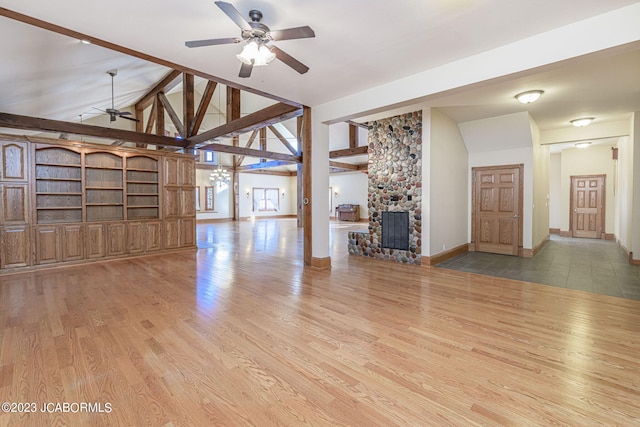 unfurnished living room with vaulted ceiling with beams, light hardwood / wood-style floors, a fireplace, and ceiling fan