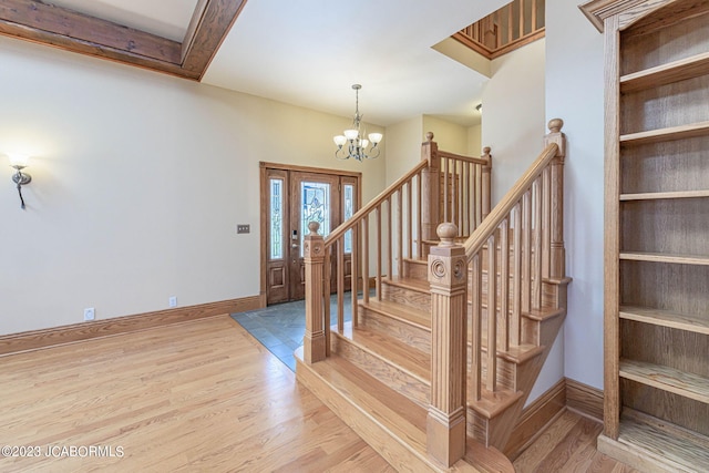 entryway with wood-type flooring and a chandelier