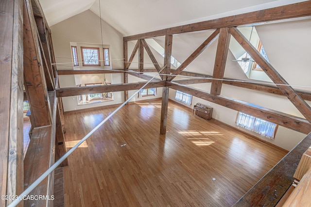 unfurnished living room with hardwood / wood-style flooring and lofted ceiling