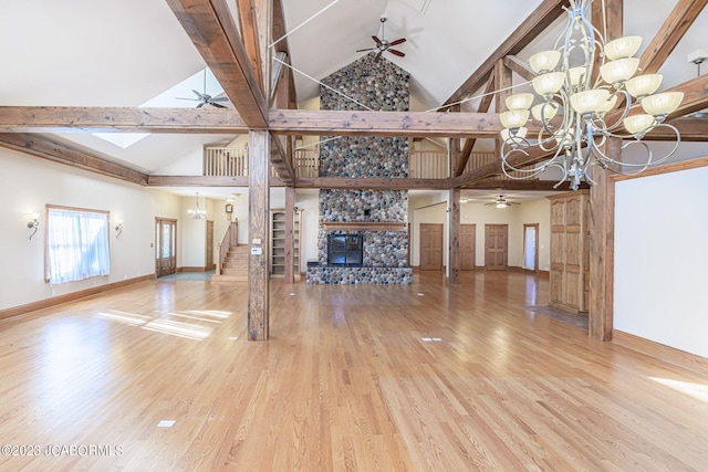 unfurnished living room with a stone fireplace, beamed ceiling, high vaulted ceiling, a notable chandelier, and wood-type flooring