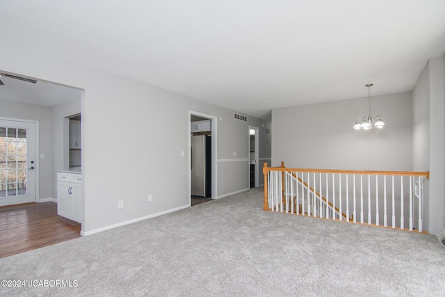 empty room with carpet floors and a chandelier