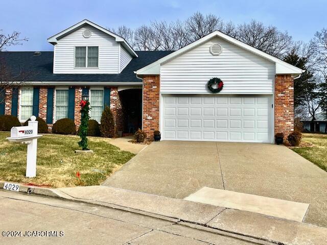 view of front of home with a front yard and a garage