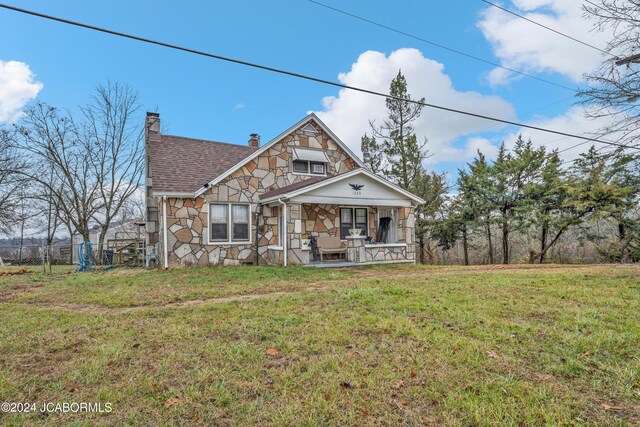 view of front of house featuring covered porch and a front yard