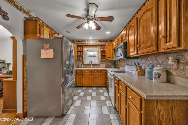 kitchen featuring tasteful backsplash, ceiling fan, sink, and stainless steel appliances