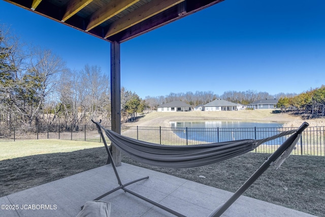 view of patio / terrace with a water view and fence