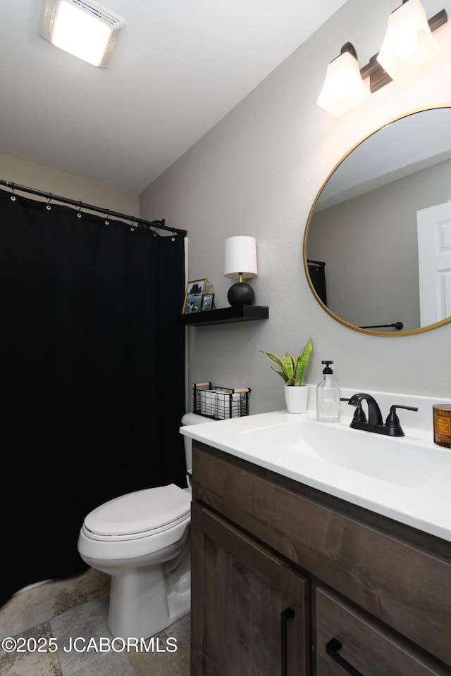 bathroom featuring curtained shower, vanity, and toilet