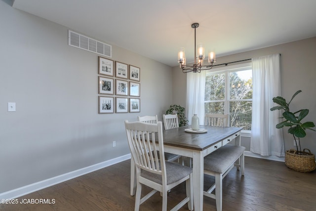 dining space featuring visible vents, a notable chandelier, baseboards, and wood finished floors