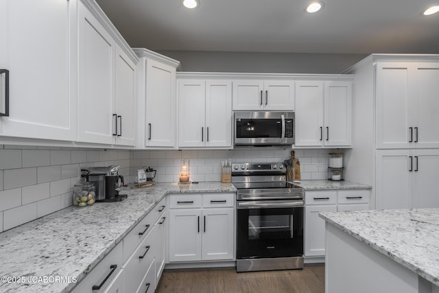 kitchen with dark wood finished floors, stainless steel appliances, recessed lighting, decorative backsplash, and white cabinets