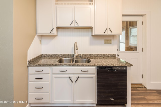 1811 W Main St, Jefferson City, MO 65109 - kitchen with black dishwasher, wood finished floors, dark stone countertops, and white cabinetry
