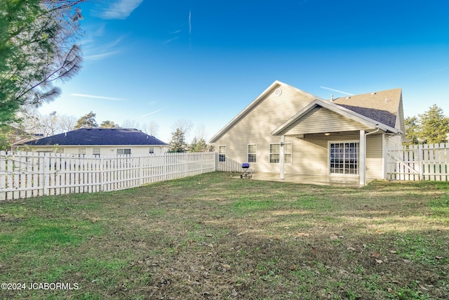 back of property with a yard and a patio