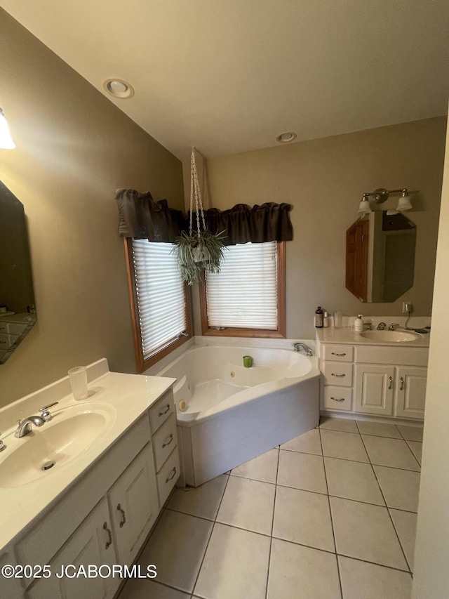 bathroom with tile patterned flooring, a tub with jets, two vanities, and recessed lighting