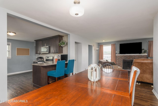 202 S Fourth St, Linn, MO 65051 - dining room featuring dark wood-style flooring, baseboards, and a brick fireplace