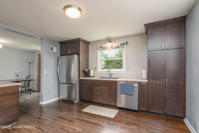 202 S Fourth St, Linn, MO 65051 - kitchen featuring a sink, light countertops, appliances with stainless steel finishes, decorative backsplash, and dark wood-style floors