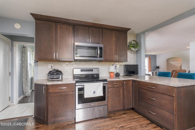 202 S Fourth St, Linn, MO 65051 - kitchen featuring a peninsula, light countertops, stainless steel appliances, and backsplash