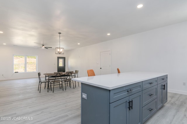 8206 Big Meadows Rd, Jefferson City, MO 65101 - kitchen featuring light wood-style floors, open floor plan, recessed lighting, light countertops, and decorative light fixtures