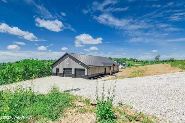 8206 Big Meadows Rd, Jefferson City, MO 65101 - view of home's exterior featuring metal roof, a detached garage, and an outbuilding