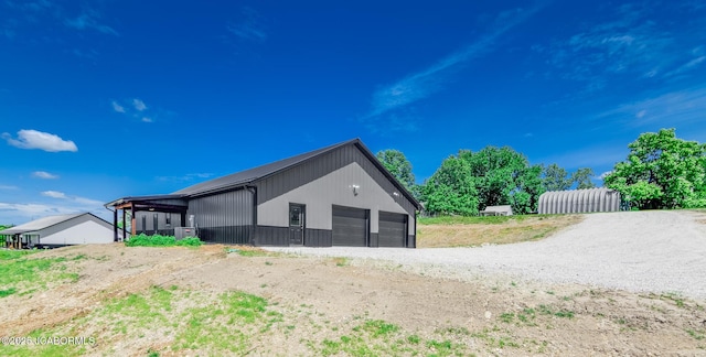 8206 Big Meadows Rd, Jefferson City, MO 65101 - view of side of property featuring a detached garage and an outbuilding