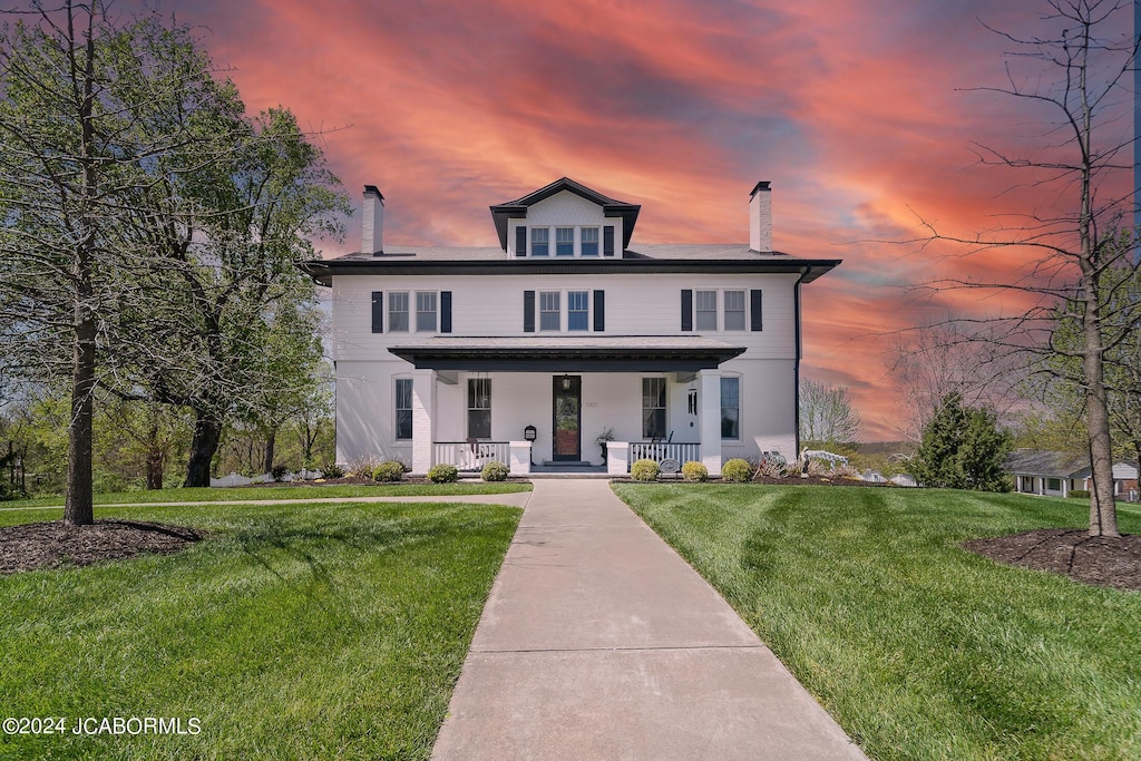 front of property with a lawn and a porch