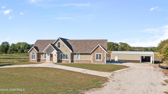 view of front facade featuring a garage, an outbuilding, and a front yard