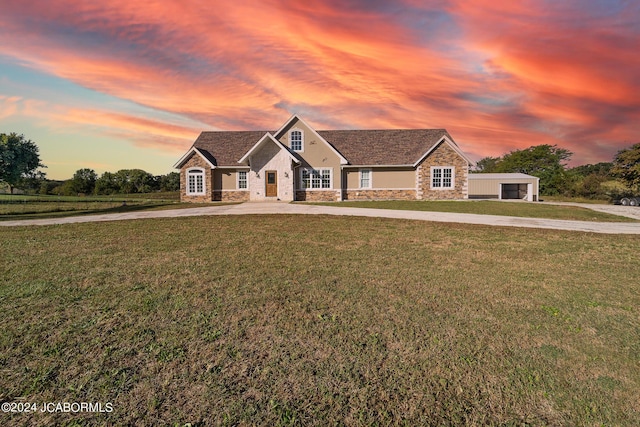 view of front of home with a lawn, a garage, and an outdoor structure