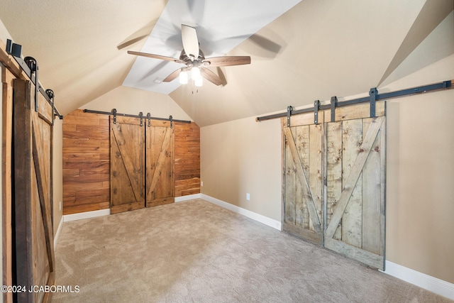 bonus room with carpet, ceiling fan, a barn door, and lofted ceiling