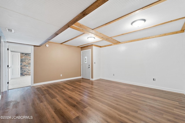 unfurnished room with beam ceiling and dark hardwood / wood-style flooring