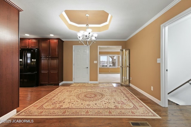 unfurnished dining area featuring crown molding, an inviting chandelier, baseboards, and dark wood-style flooring