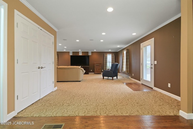 carpeted living area with baseboards, a baseboard heating unit, recessed lighting, crown molding, and visible vents