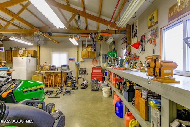 garage featuring a workshop area and freestanding refrigerator