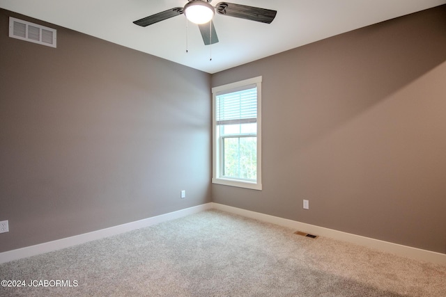 unfurnished room featuring a ceiling fan, carpet flooring, baseboards, and visible vents