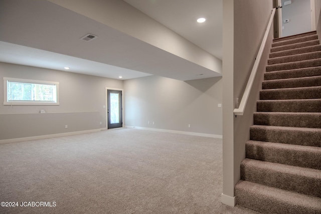 basement featuring visible vents, baseboards, and carpet