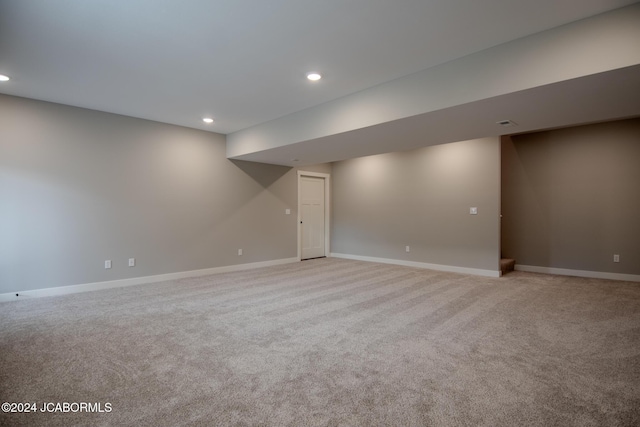 finished below grade area featuring recessed lighting, light colored carpet, and baseboards