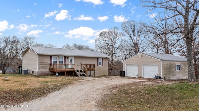 view of front of house featuring an outbuilding, a garage, a front lawn, and a deck