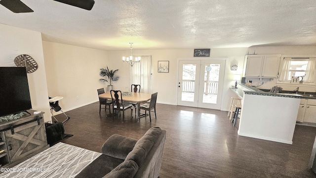 interior space with dark hardwood / wood-style flooring, ceiling fan with notable chandelier, and a textured ceiling