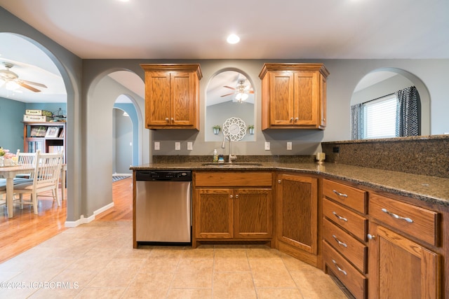 kitchen featuring a sink, dishwasher, brown cabinetry, and a ceiling fan