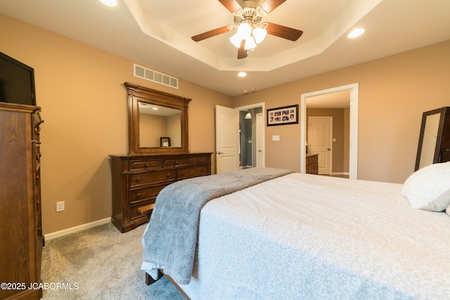 bedroom featuring visible vents, baseboards, light carpet, recessed lighting, and a raised ceiling