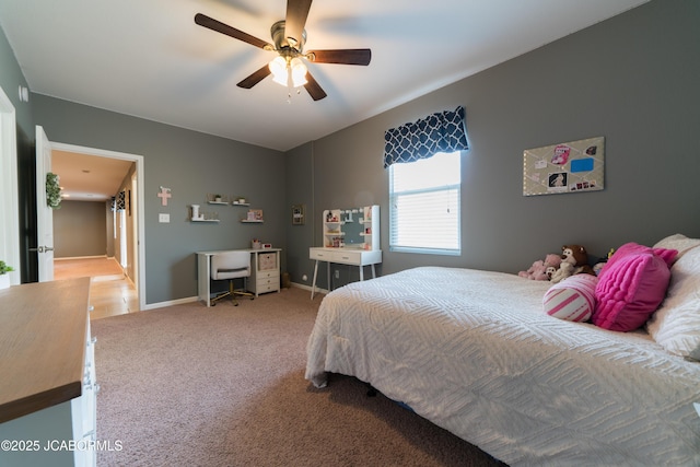 bedroom featuring baseboards, light colored carpet, and ceiling fan