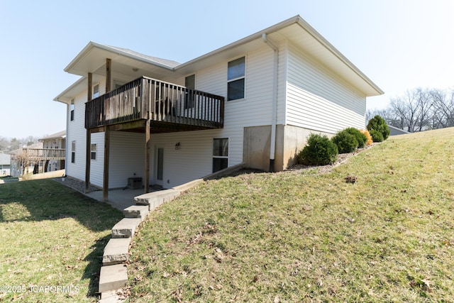 back of house featuring a deck, a patio, and a lawn