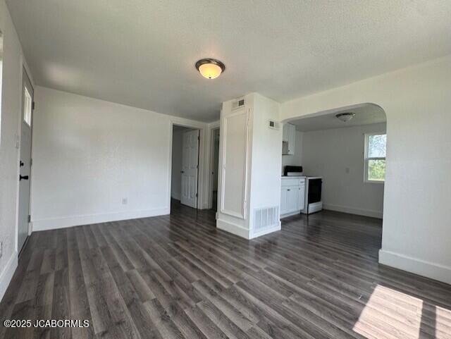 210 Academy St, Clarksburg, MO 65025 - unfurnished living room with arched walkways and dark wood finished floors