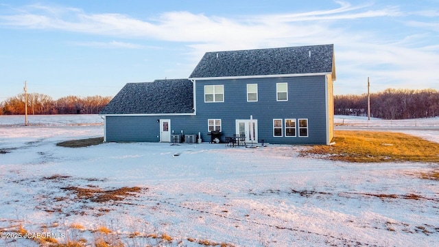 view of snow covered back of property