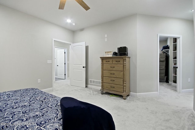 carpeted bedroom with a spacious closet and ceiling fan