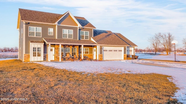 view of front of property featuring a garage, a front lawn, and a porch