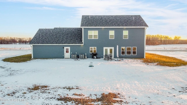 snow covered property with central AC unit