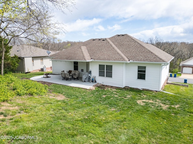 2414 Camzie Dr, Jefferson City, MO 65101 - back of house with a shingled roof, a patio area, and a yard