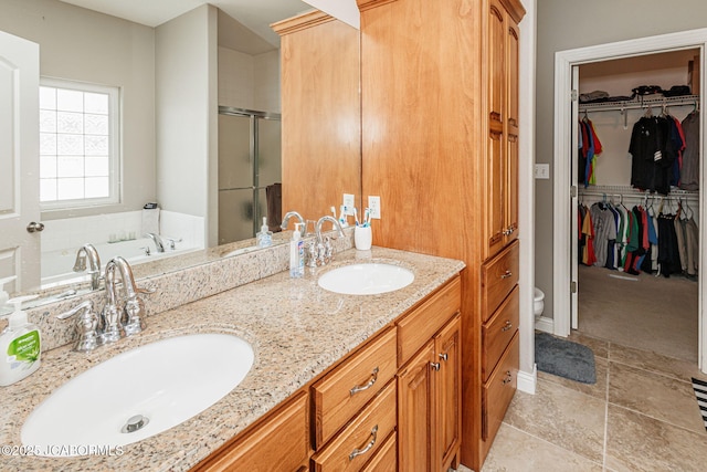 2414 Camzie Dr, Jefferson City, MO 65101 - bathroom with a stall shower, double vanity, a sink, and a spacious closet
