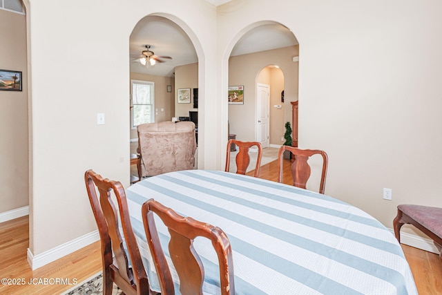 2414 Camzie Dr, Jefferson City, MO 65101 - dining space with arched walkways, light wood finished floors, ceiling fan, and baseboards