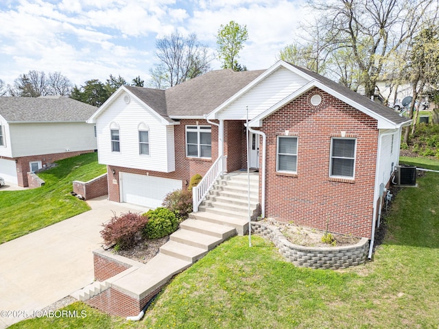 2414 Camzie Dr, Jefferson City, MO 65101 - view of front of house with a garage, cooling unit, concrete driveway, brick siding, and a front lawn