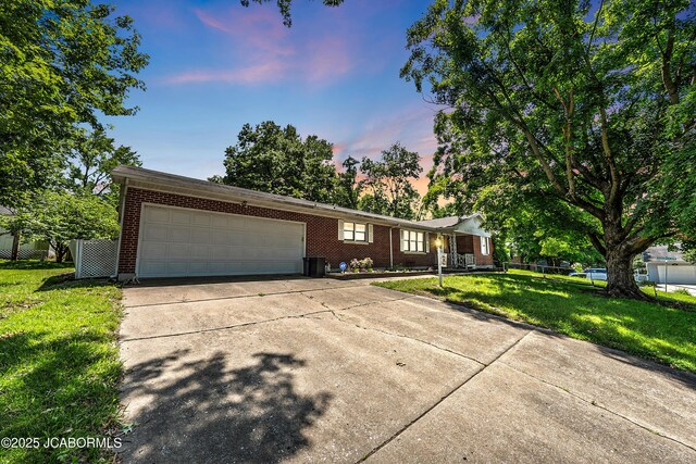 409 Lorene St, California, MO 65018 - single story home with driveway, an attached garage, brick siding, and a lawn