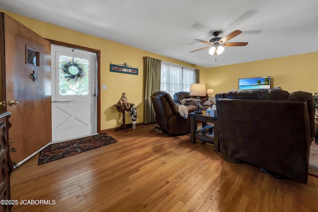 409 Lorene St, California, MO 65018 - living room with light wood finished floors, a ceiling fan, and a textured ceiling
